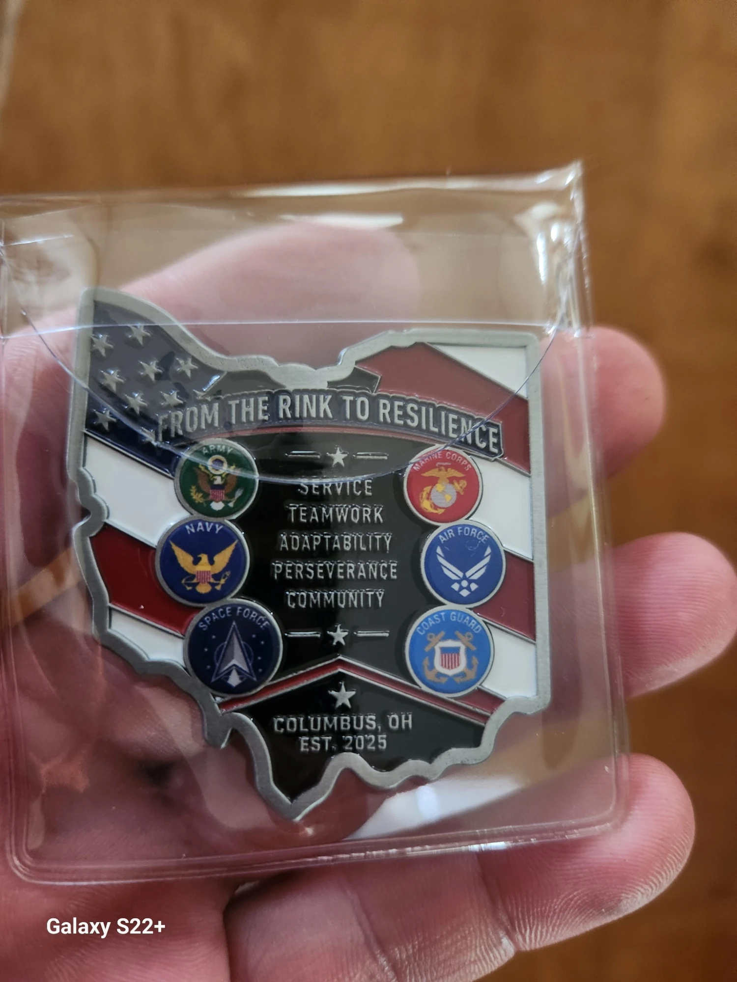 The same coin's reverse: From the Rink to Resilience above the Army, Navy, Space Force, Marine Corps, Air Force and Coast Guard seals, around the words Service, Teamwork, Adaptability, Perseverance, Community.